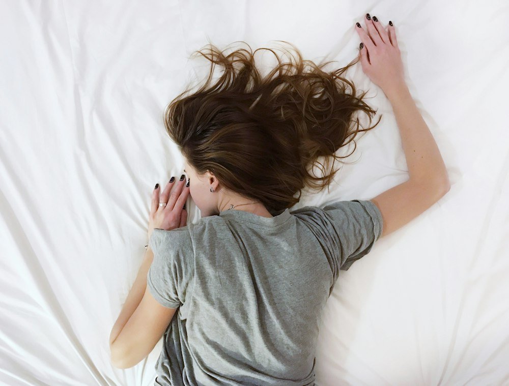Persona descansando, agotada, sobre la cama